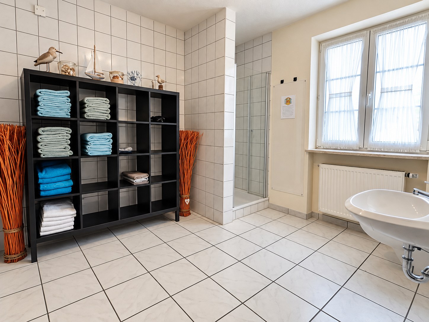 Helles Badezimmer mit Dusche und Handtuchregal