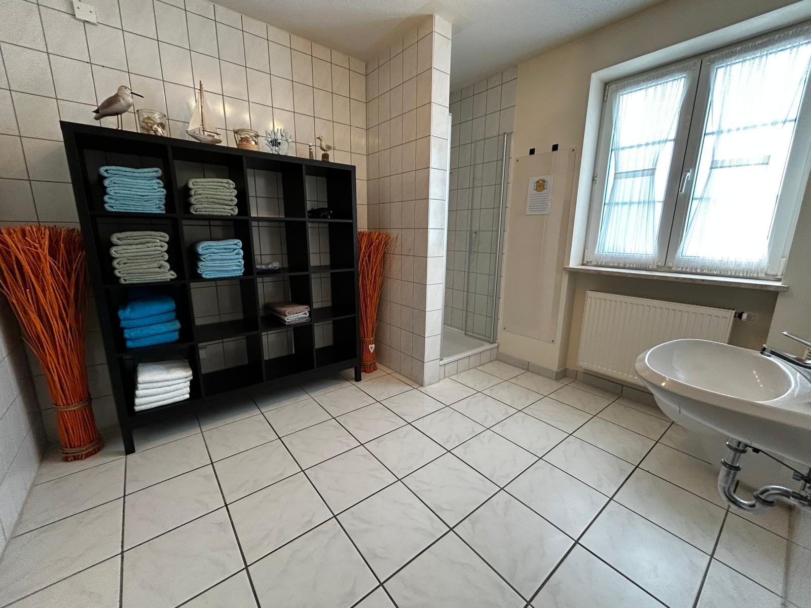 Badezimmer mit Dusche und Handtüchern