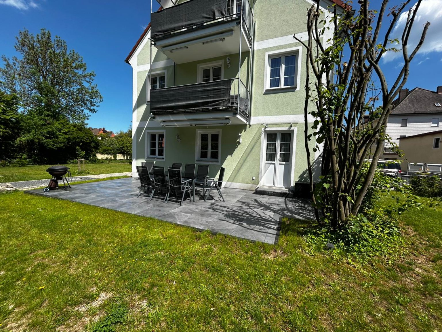 Große Gartenterrasse mit Esstisch und Grill