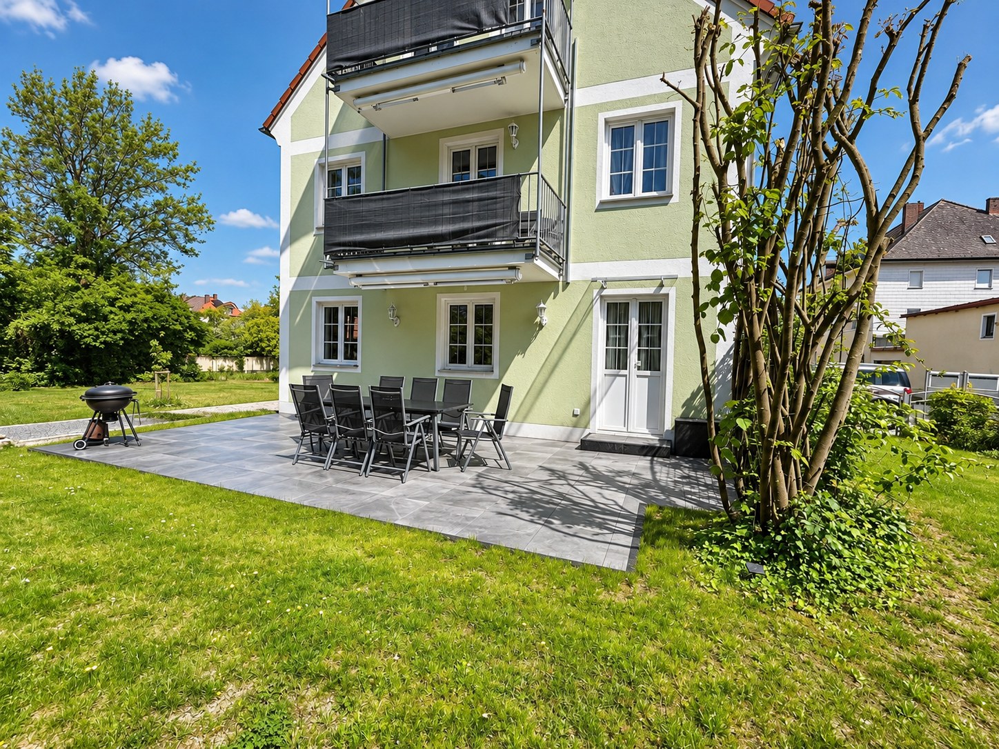 Terrasse mit Tischgruppe und Grill vor dem Haus